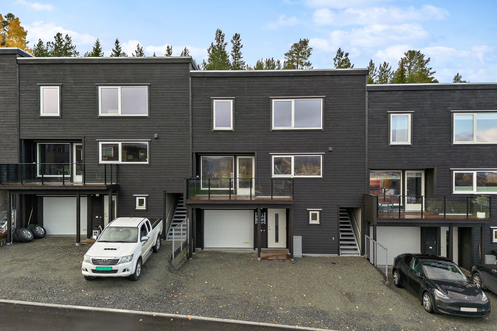 Det er gruslagt gårdsplass samt parkering i integrert garasje (med direkte adkomst til vaskerom). Trapp til høyre leder til hage og terrasse på baksiden. Galleribilde