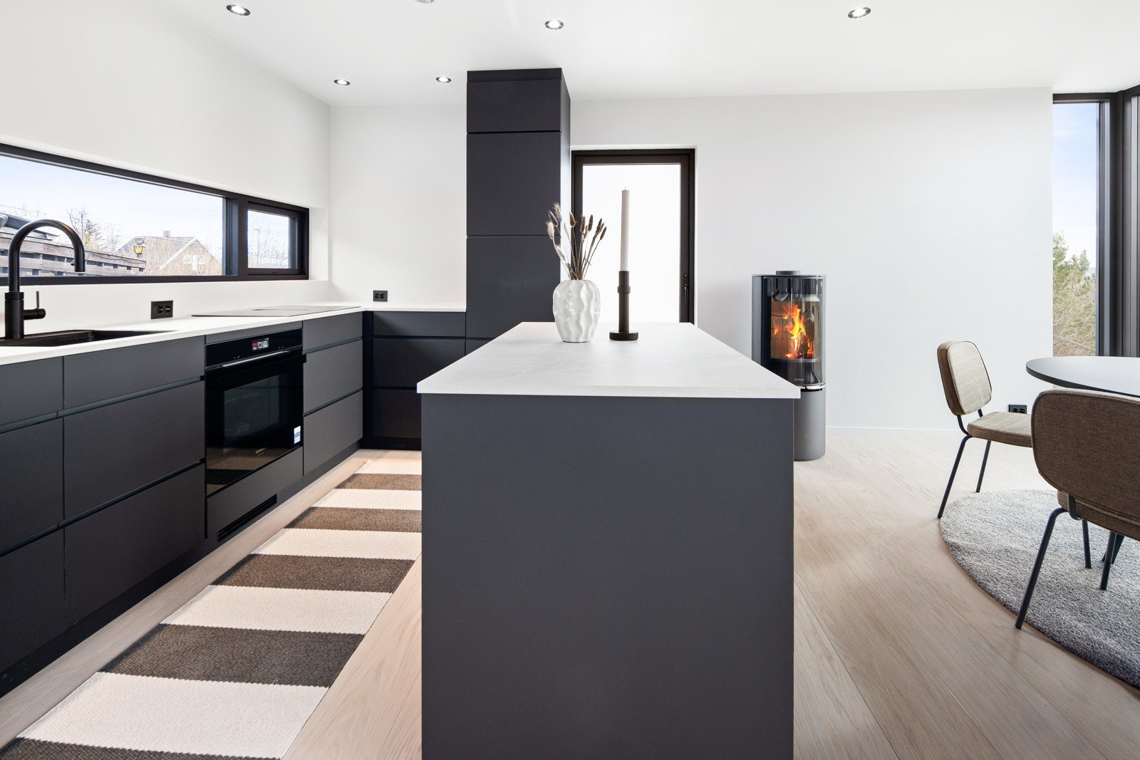 Delikat og stilrent kjøkken med slette fronter i lun, mørk gråtone. Galleribilde