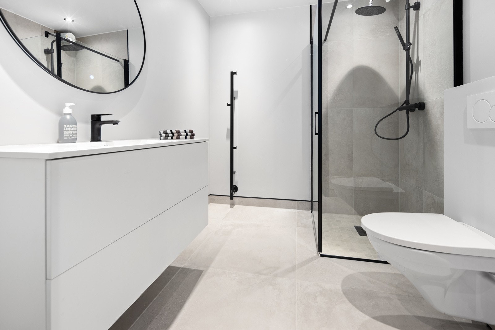 Baderommet i tilknytning til hovedsoverommet er lyst og delikat med fliser på gulv og i dusjnisje. Galleribilde