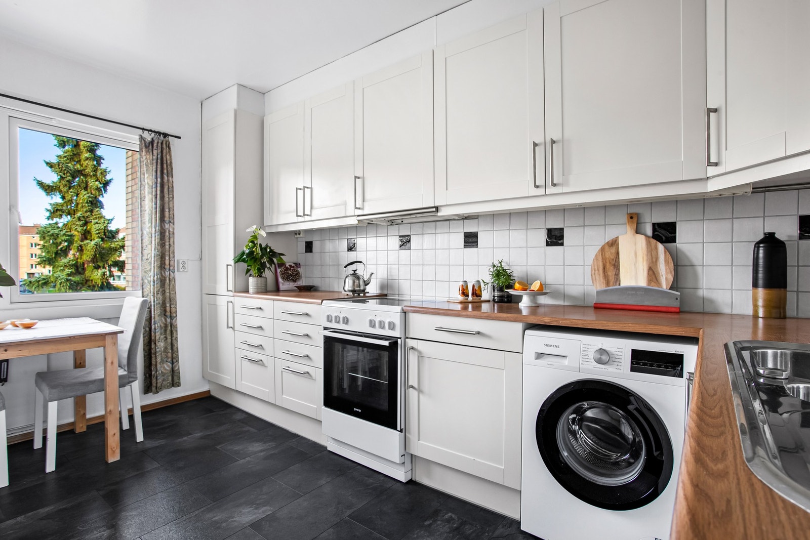 Kjøkkenet ligger adskilt fra stuen og har en optimal løsning. Dette gir svært godt med benke- og skapplass, og det er i tillegg god plass til eget frokostbord. Galleribilde