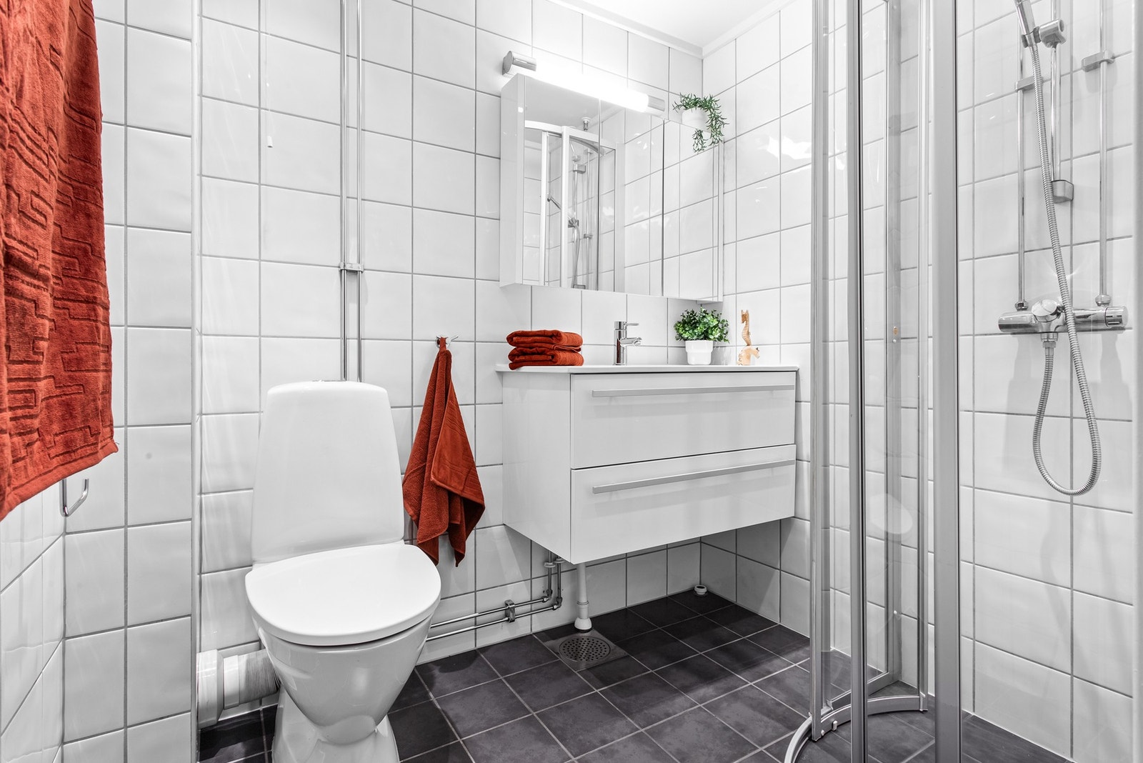 Badet fremstår som solid og veldig funksjonelt, med nøtrale gulv og veggfliser samt gulvvarme. Galleribilde