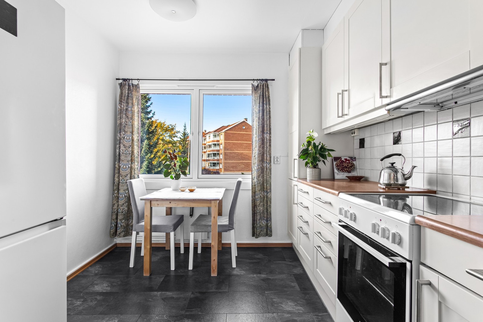 Kjøkkenet ligger adskilt fra stuen og har en optimal løsning. Dette gir svært godt med benke- og skapplass, og det er i tillegg god plass til eget frokostbord. Galleribilde