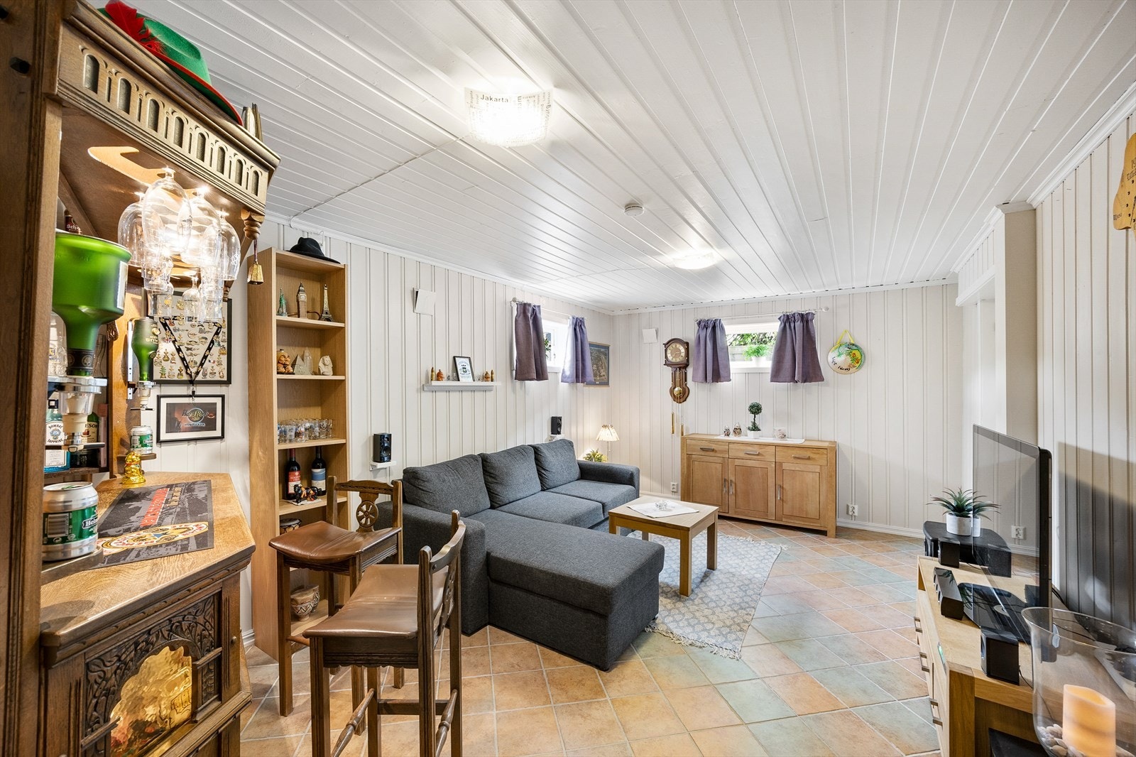 Koselig innredet kjellerstue med bar og sittegruppe Galleribilde