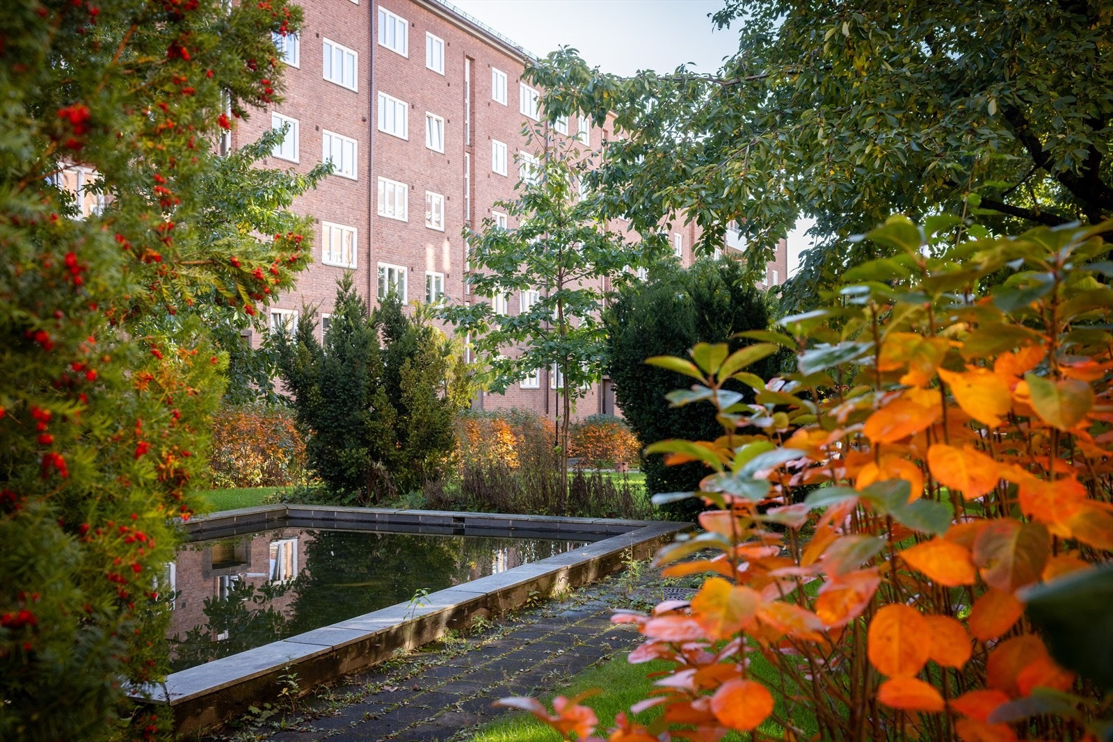 Bakgården er en av områdets vakreste med flott beplantning og vannspeil. Galleribilde