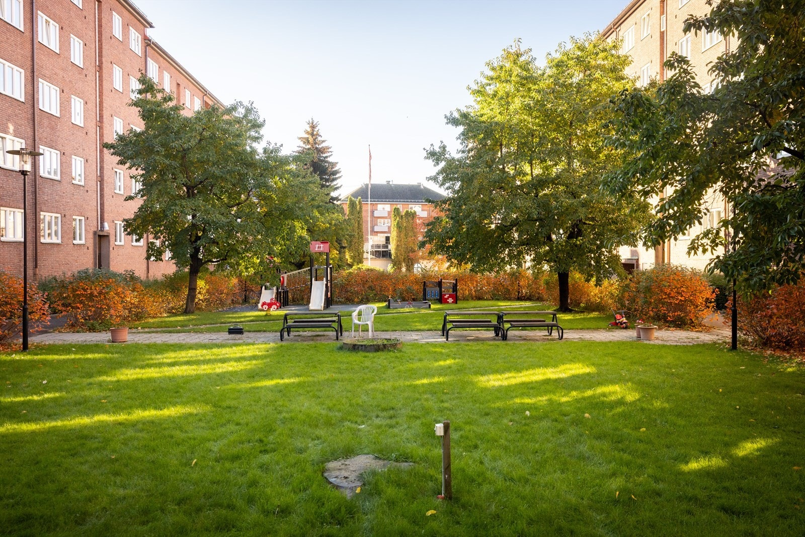 Borettslagets uteplass er hyggelig, hagemessig opparbeidet - med sittegrupper, grill og gressplen. Galleribilde