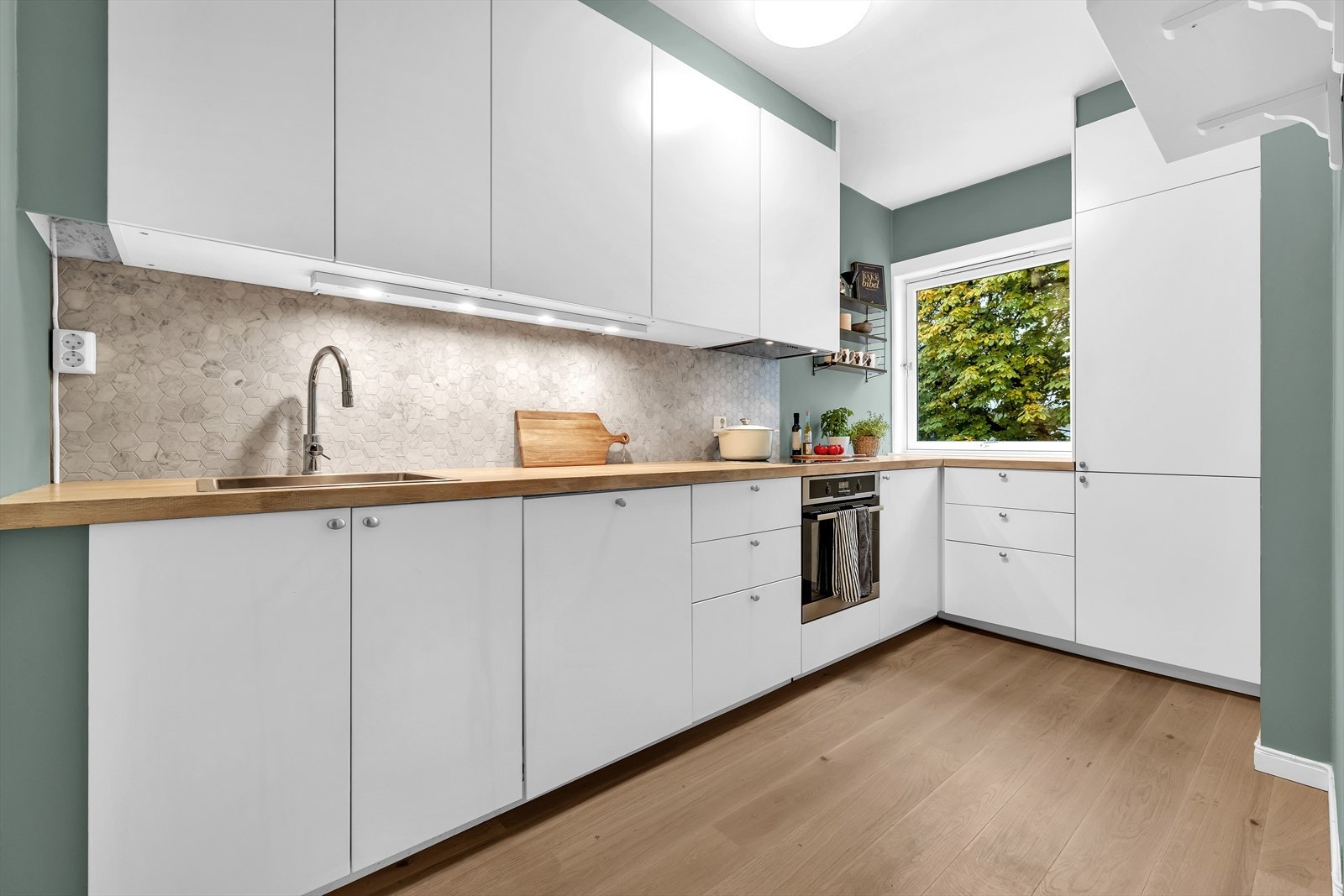 Kjøkkenet ligger separat til og fremstår tidsriktig og moderne med godt med skap- og benkeplass. Galleribilde