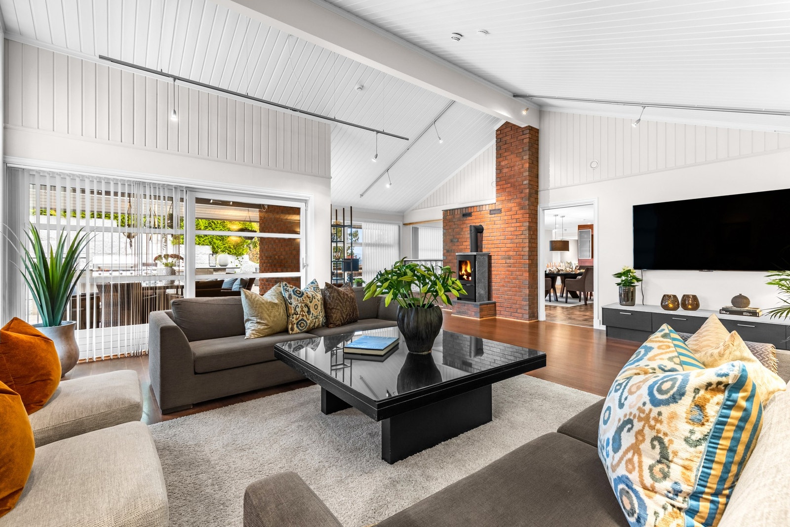 Stuens høye tak skaper en følelse av luftighet og romslighet, med sine store vinduer som gir flotte lysforhold Galleribilde