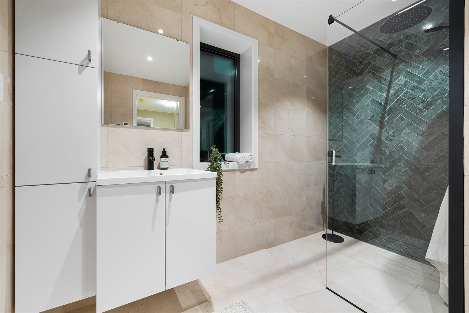 Dusjhjørnets vegger prydes av aktuelle fliser i grønne nyanser, lagt i klassisk fiskebeinsmønster. Galleribilde