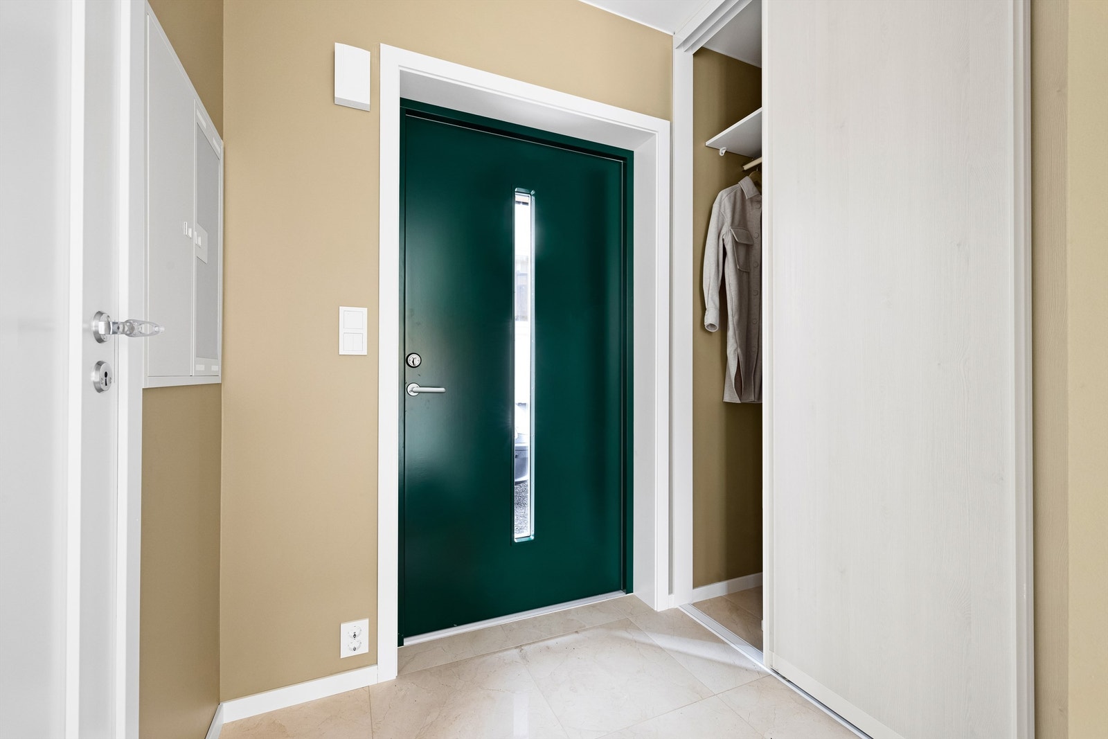 Skyvedørsgarderobe i entreen oppbevarer yttertøyet ute av syne, men likevel lett tilgjengelig. Gulvet er flislagt. Galleribilde