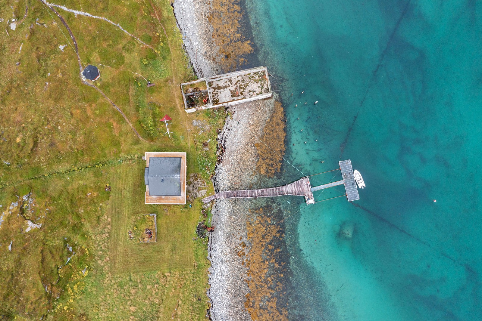 Skjult perle på Vannøya/Lille Skorøya med strandlinje og flytebrygge.