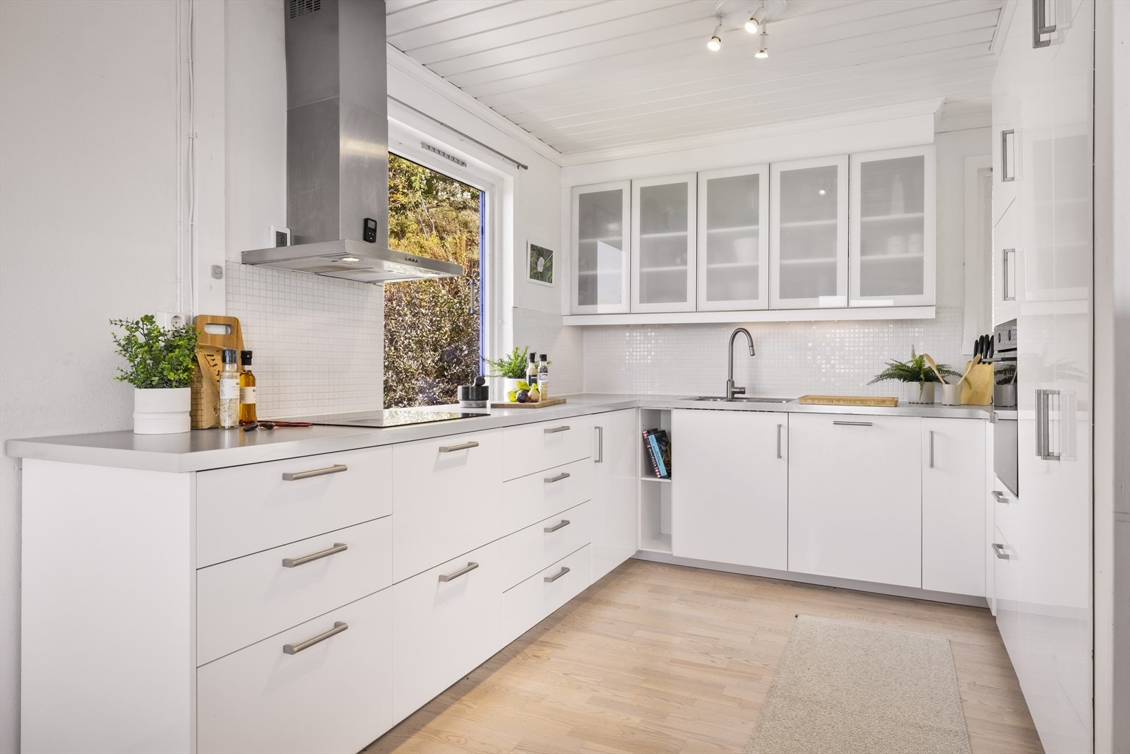 Kjøkkenet finner sin velegnede plass i hjørnet av rommet og er av lyse slette fronter og inneholder laminat benkeplate, stål oppvaskkum og ventilator. Enkelte av overskapene har glassfronter og over benkeplaten er det benyttet fliser. Galleribilde