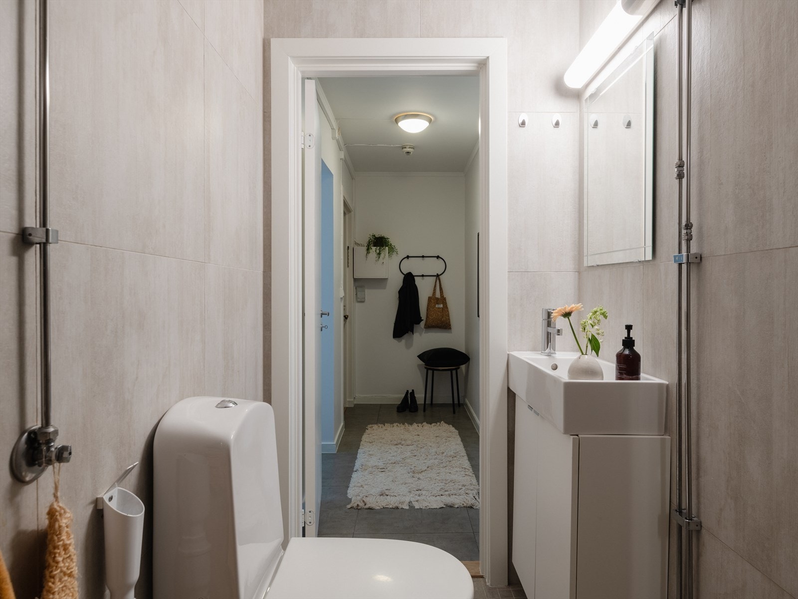 Badet er innredet med toalett, dusjhjørne og servant på underliggende servantskap. Galleribilde