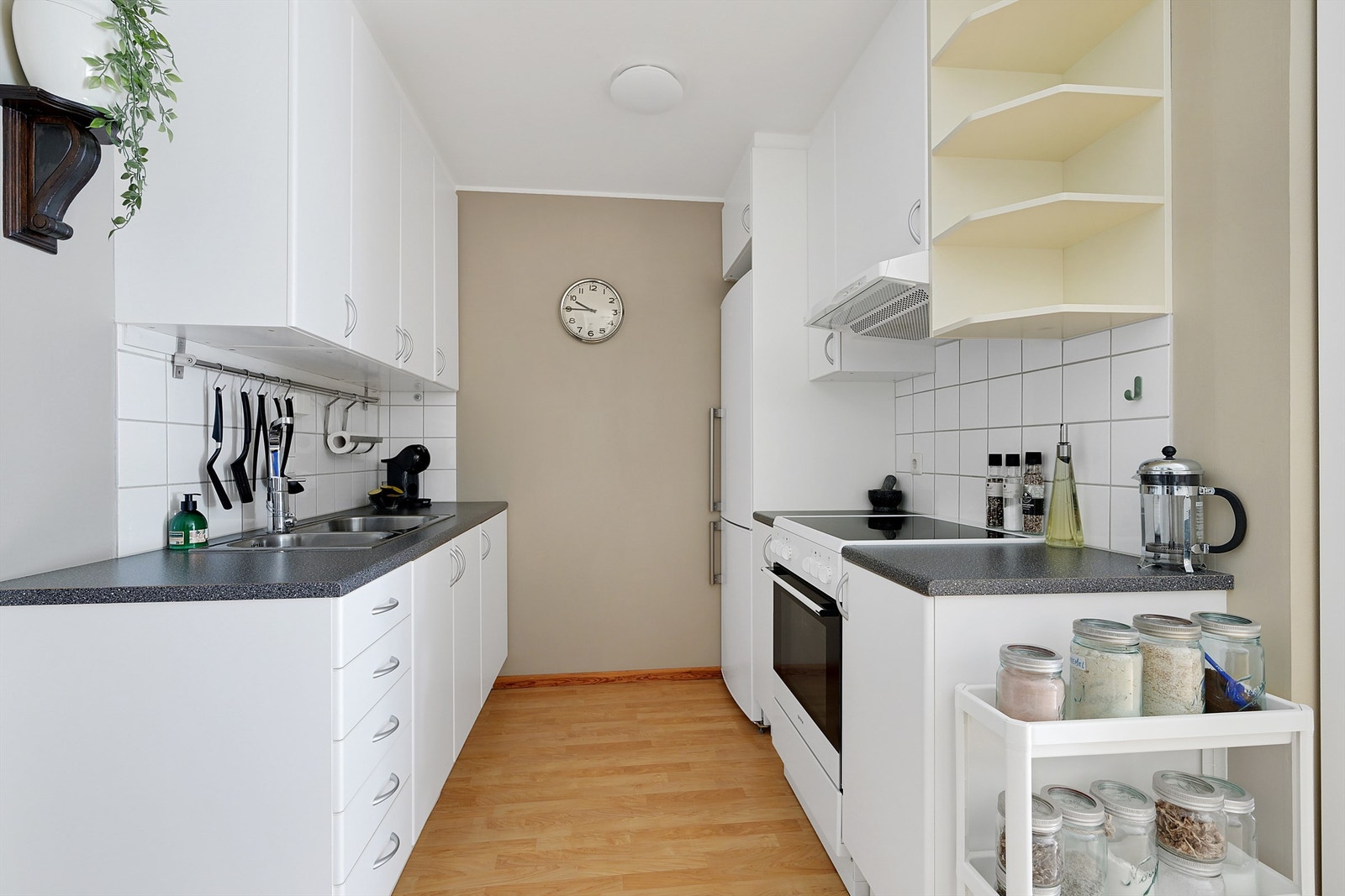 Kjøkkenet har innredning med glatte fronter og benkeplate av laminat, det er avsatt nisjer til kjøleskap og komfyr. Galleribilde