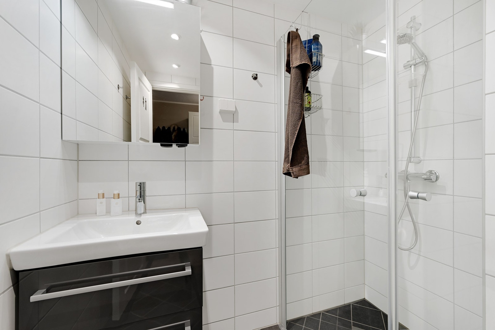 Badet er innredet med nedfelt servant, toalett og dusjvegger/hjørne. Galleribilde