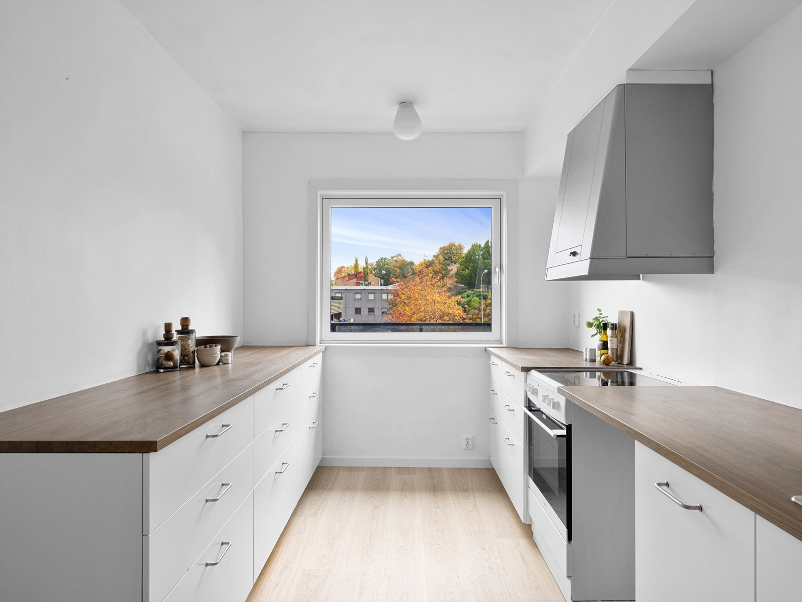 Romslig kjøkken med pen hvit innredning. Stort vindu som gir mye lys. Komfyr og ny oppvaskmaskin medfølger. Klargjort for vaskemaskin. Galleribilde