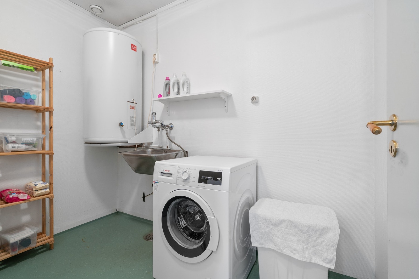 Praktisk vaskerom med opplegg for vaskemaskin, utslagsvask og varmtvannsbereder. Galleribilde