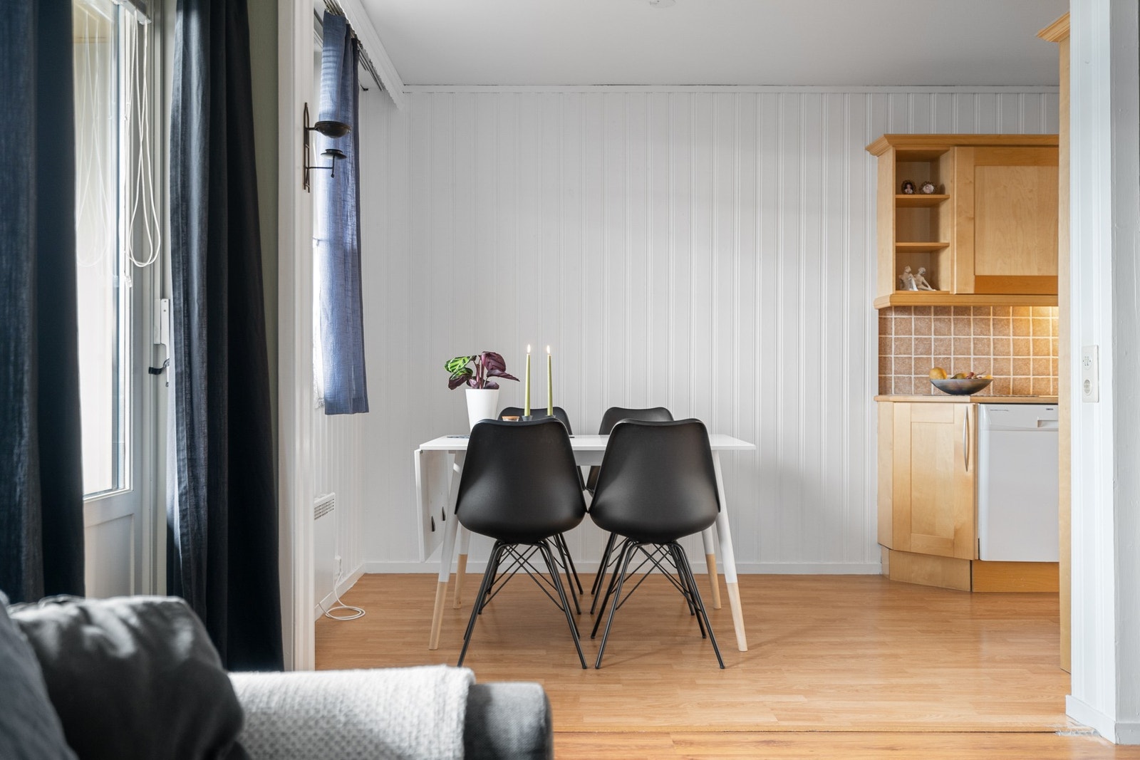 Naturlig avdeling mellom stue og kjøkken med et spisebord. Galleribilde