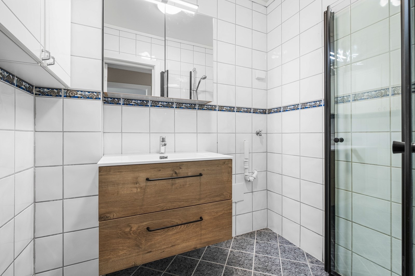 Pent bad med moderne innredning og opplegg for vaskemaskin Galleribilde
