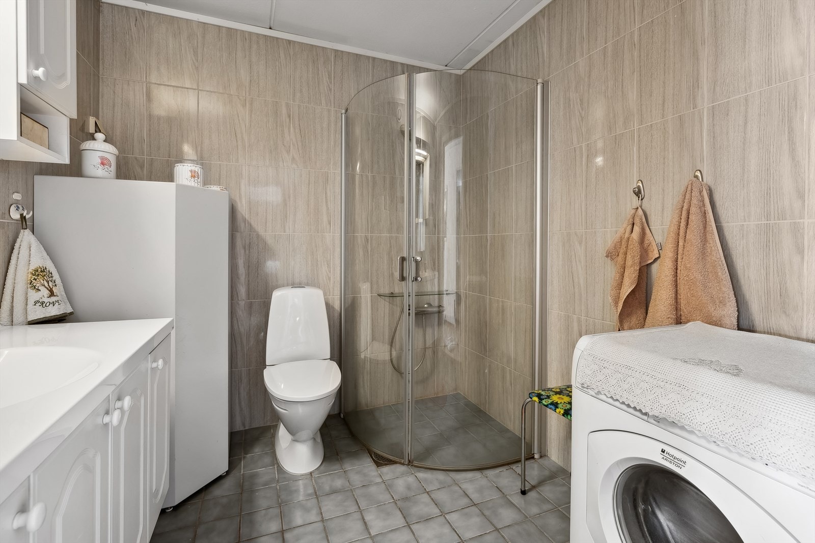 Videre er rommet innredet med baderomsinnredning med servant, veggskap, speil, toalett og dusjhjørne. Baderommet er fra byggeår, og takstmann opplyser at det må oppgraderes for å tåle normal bruk etter dagens krav og har fått tilstandsgrad 3. Galleribilde