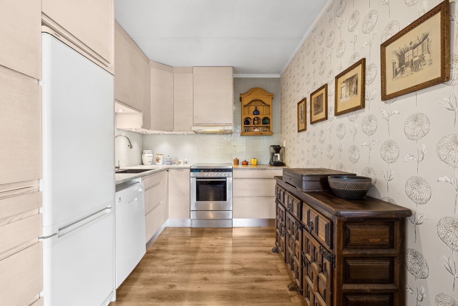 Kjøkkenet er innredet i en praktisk form med godt med skap- og oppbevaringsplass. Innredningen er med lyse glatte fronter og benkeplate i laminat. Galleribilde