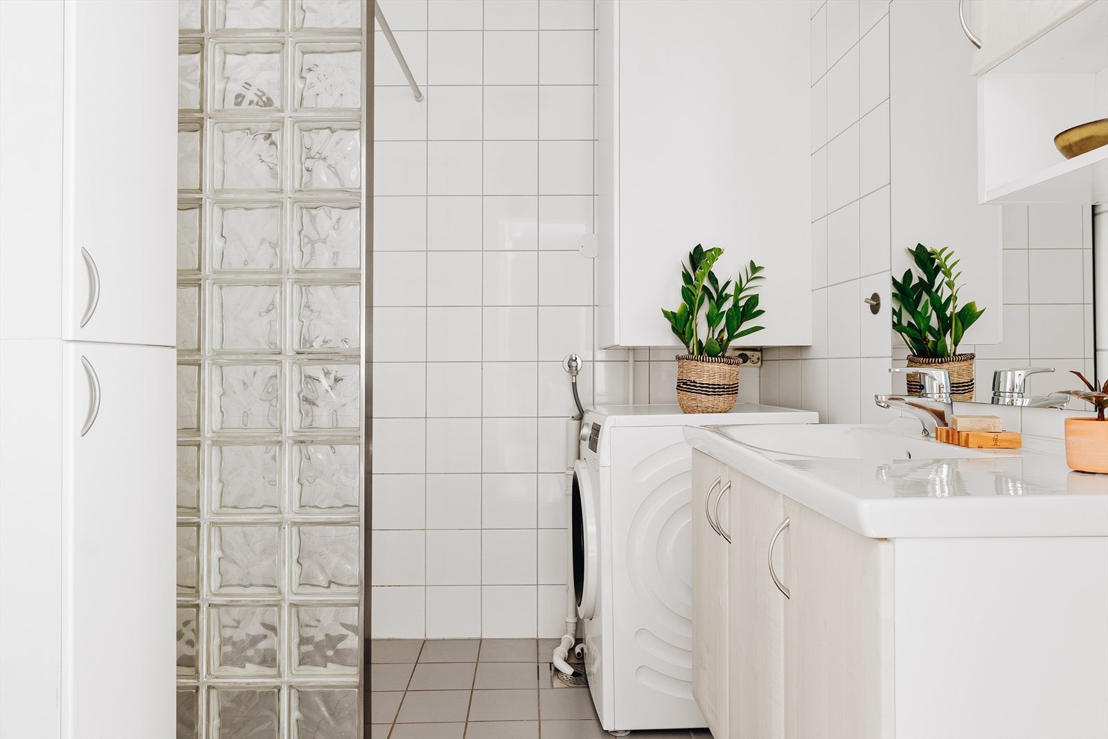 Badet er pent helfliset med hvite fliser på vegger og lysegrå på gulv. Galleribilde