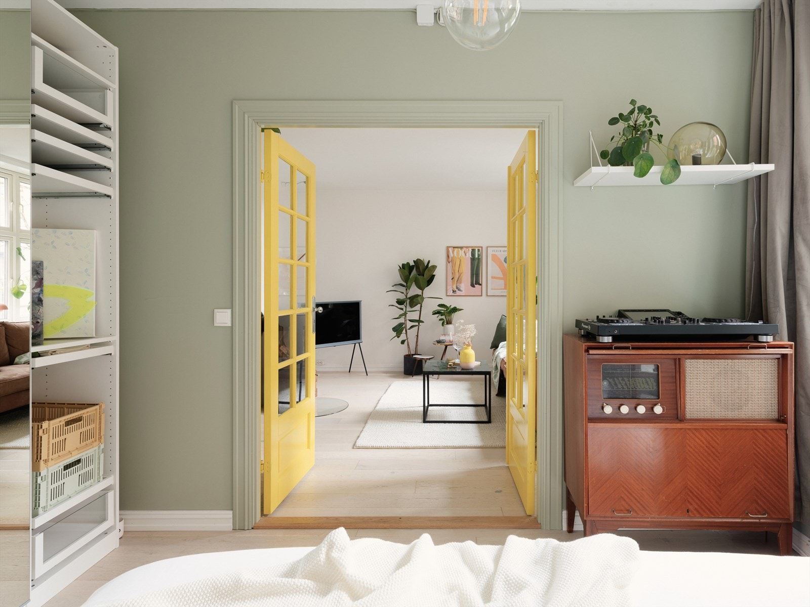 De doble fløydørene i gul bryter opp den ellers duse fargepaletten, og gir leiligheten et kult og personlig preg. Galleribilde