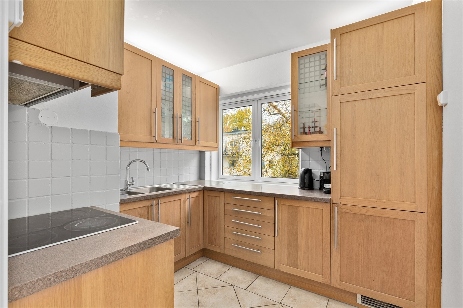 Innredningen har 2 stk. vitrineskap med belysning og belysning under overskaper. Malte fliser på vegg mellom benk og overskaper. Galleribilde