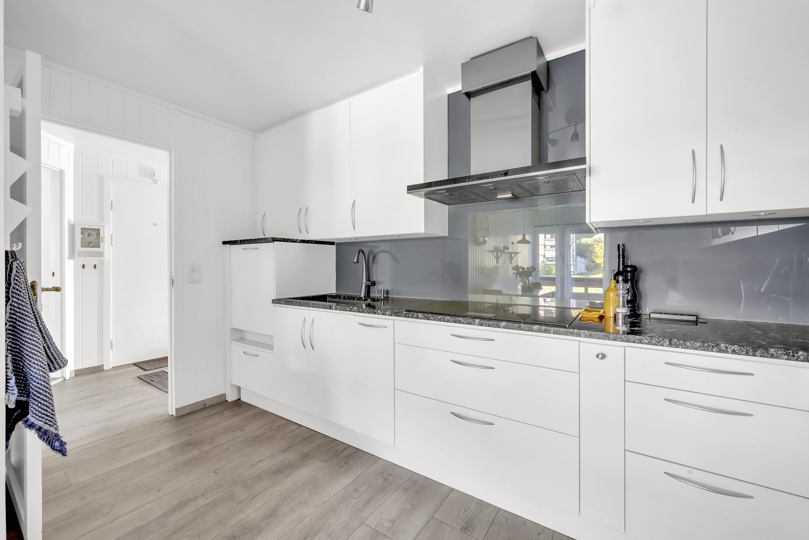 Kjøkkenet har stilrene benkeplater av stein, underlimt oppvaskkum, og ett-greps armatur for et pent uttrykk Galleribilde