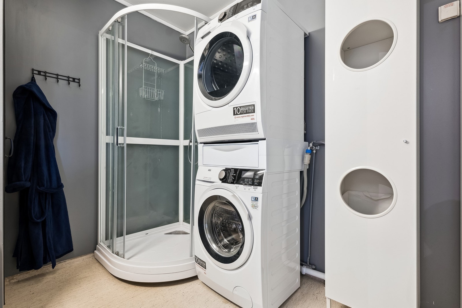 Badet er utstyrt med dusjkabinett, servantinnredning og opplegg for vaskemaskin Galleribilde