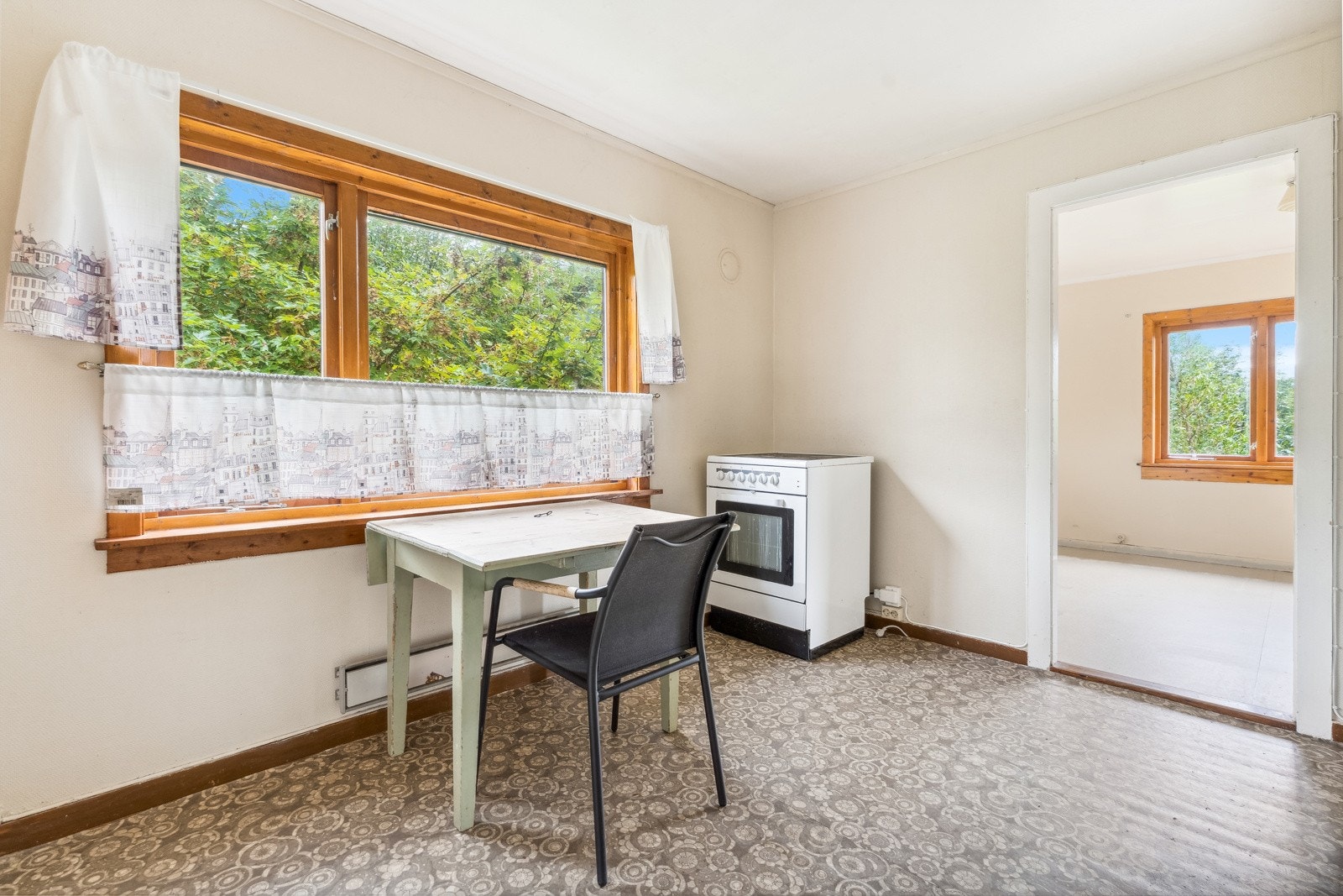 Kjøkkenet har spiseplass ved vindauget og gjennomgang til stove Galleribilde