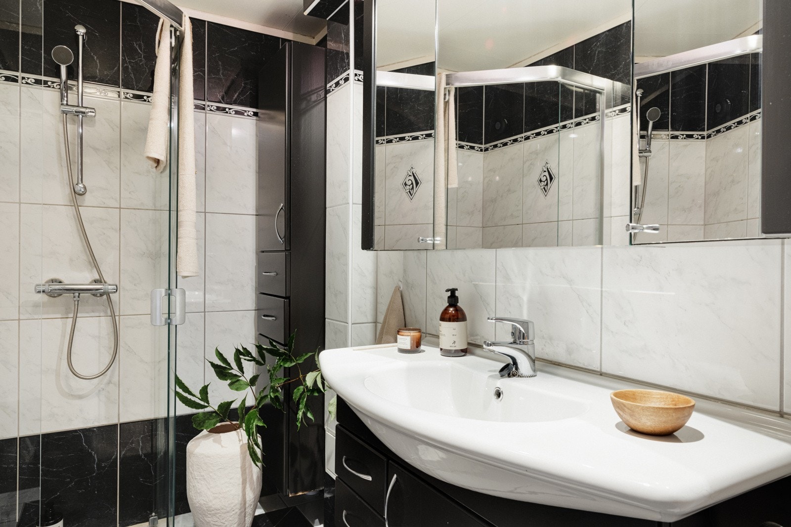 Badet er helfliset med takplater i himling, og varmekabler i gulv. Det er innredet med dusjhjørne, toalett og baderomsinnredning. Galleribilde