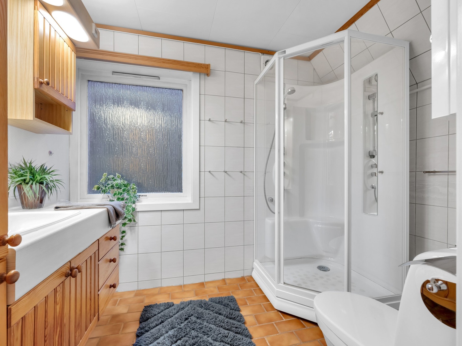 Bad på 5 kvm med varmekabler i gulv. Godt med lagringsplass i baderomsinnredningen, og også her har det blitt dusjet i kabinett. Galleribilde