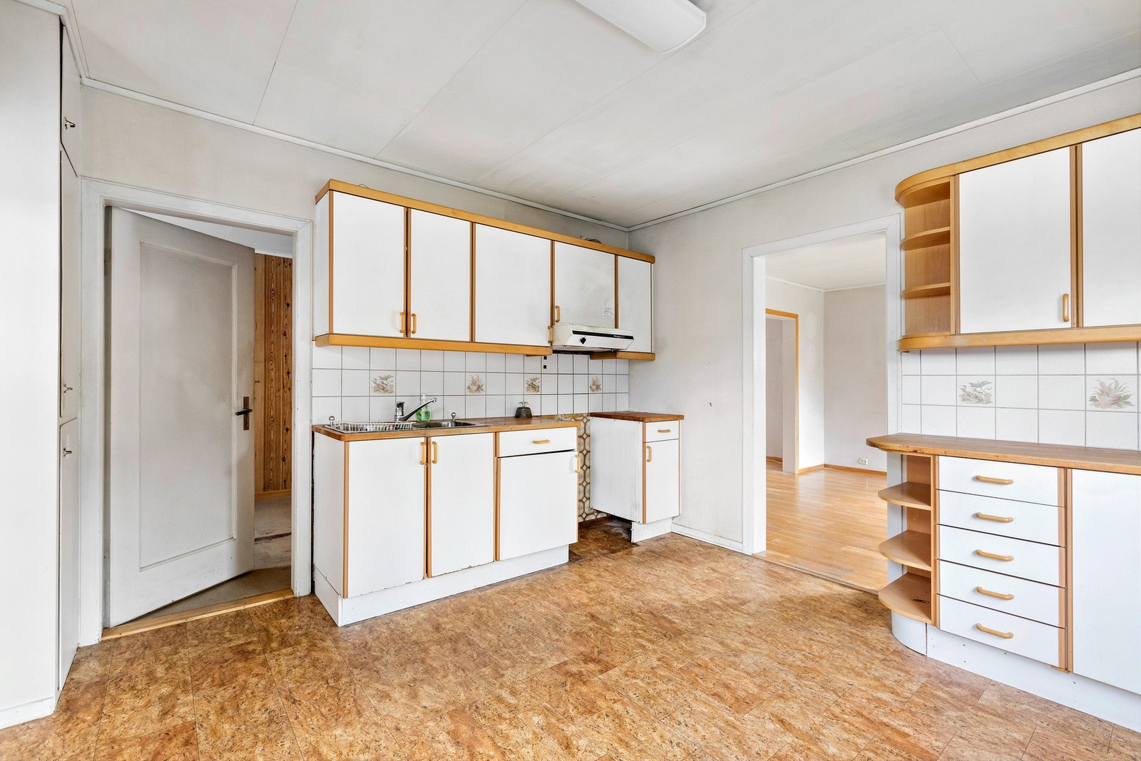 Det er vinylflis på gulv, flis på vegg over benkeplate og malte overflater på vegger. Galleribilde