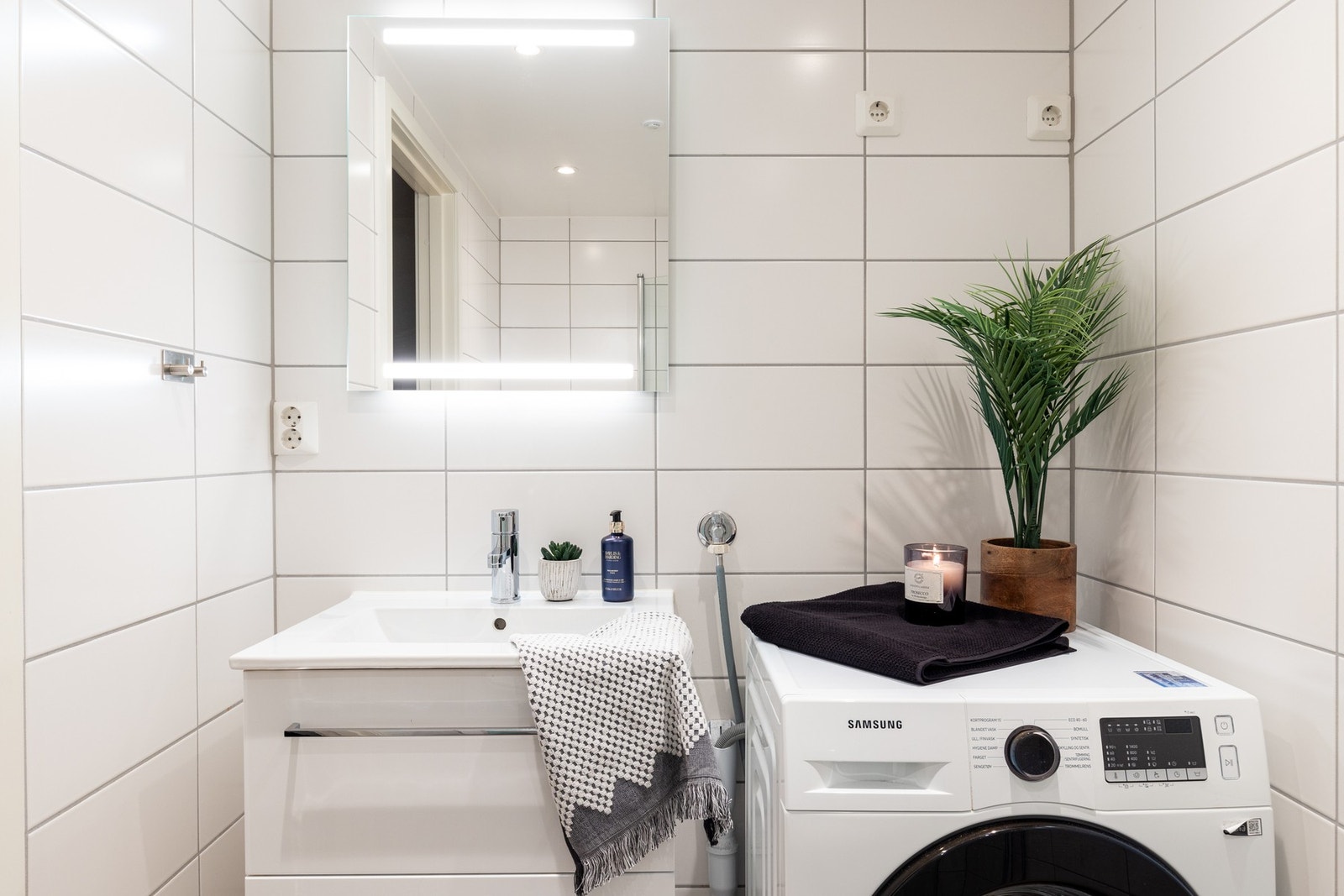 Badet har en stilren innredning med heldekkende servant, speil på vegg med lys og stikkontakt over servant. Galleribilde