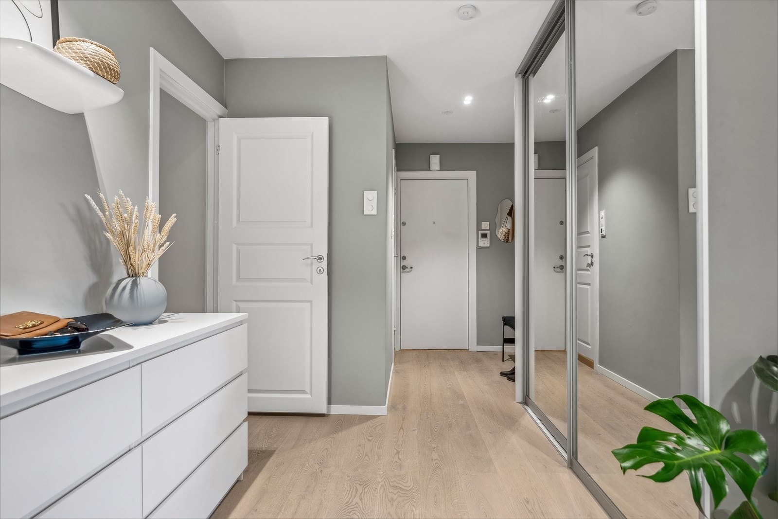 Innbydende entré av svært god størrelse, hvor man raskt legger merke til leilighetens særpreg med elegant 1-stavs eikeparkett, mens veggflatene er malt opp i en delikat gråtone Galleribilde