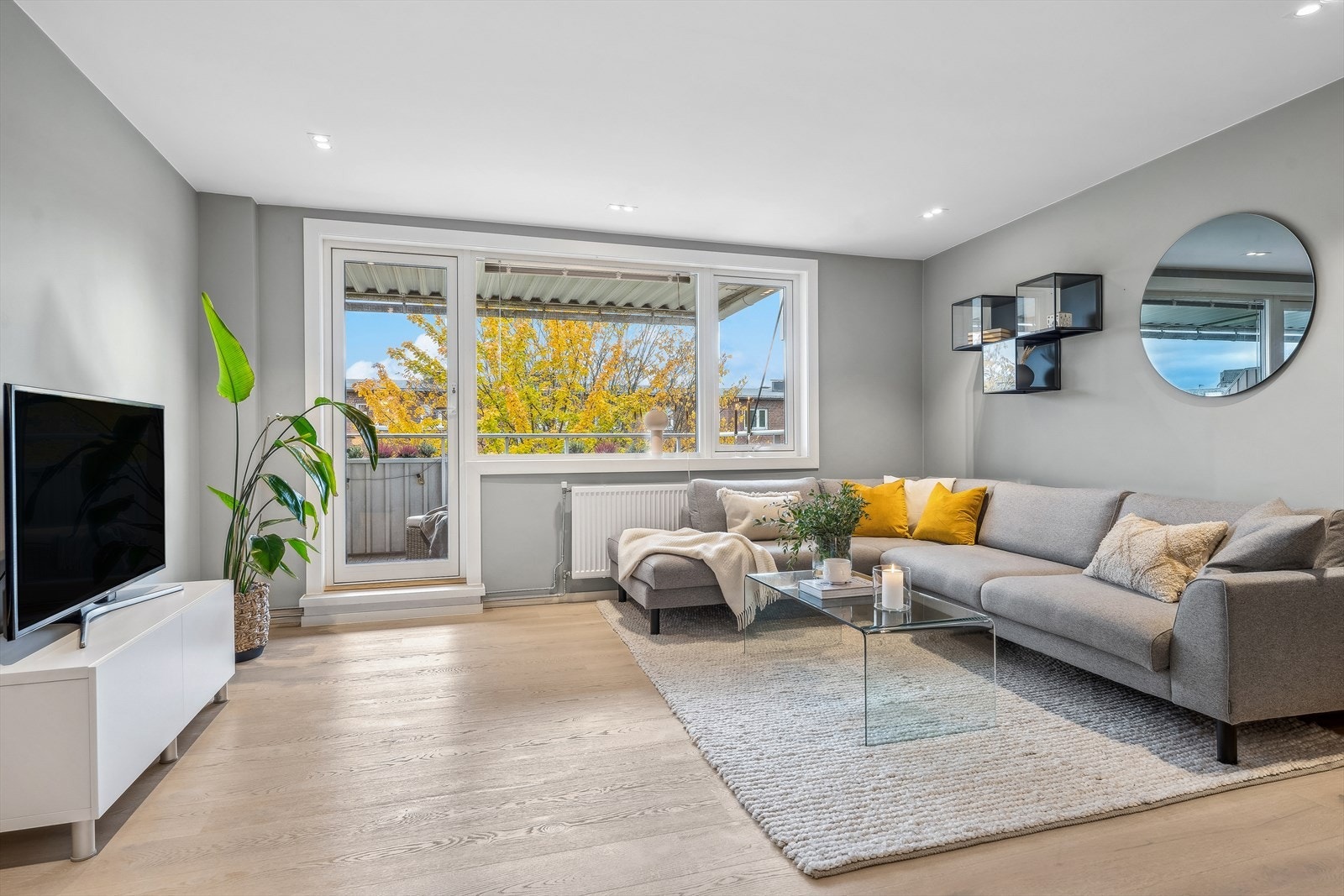 Store vindusflater fyller rommet med dagslys, noe som skaper en lys og luftig atmosfære Galleribilde