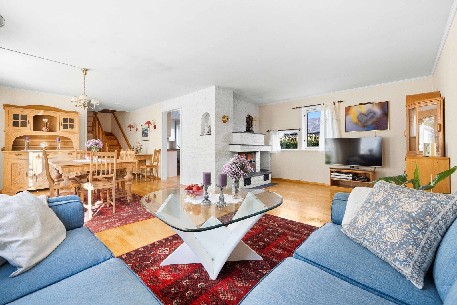 Stuen oppleves som et sosialt oppholssrom med naturlig plass til både sofagruppe, spisebord og annet ønskelig møblement Galleribilde