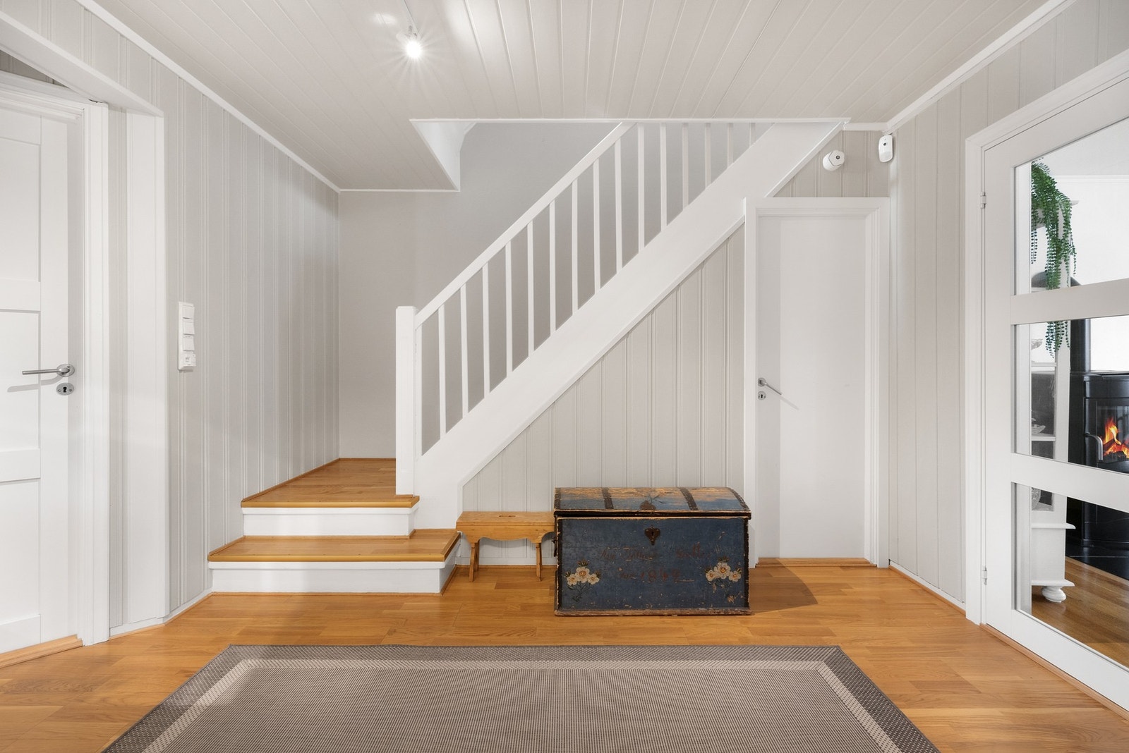 Romslig entrè, og trapp som leder opp til boligens 2.etasje Galleribilde