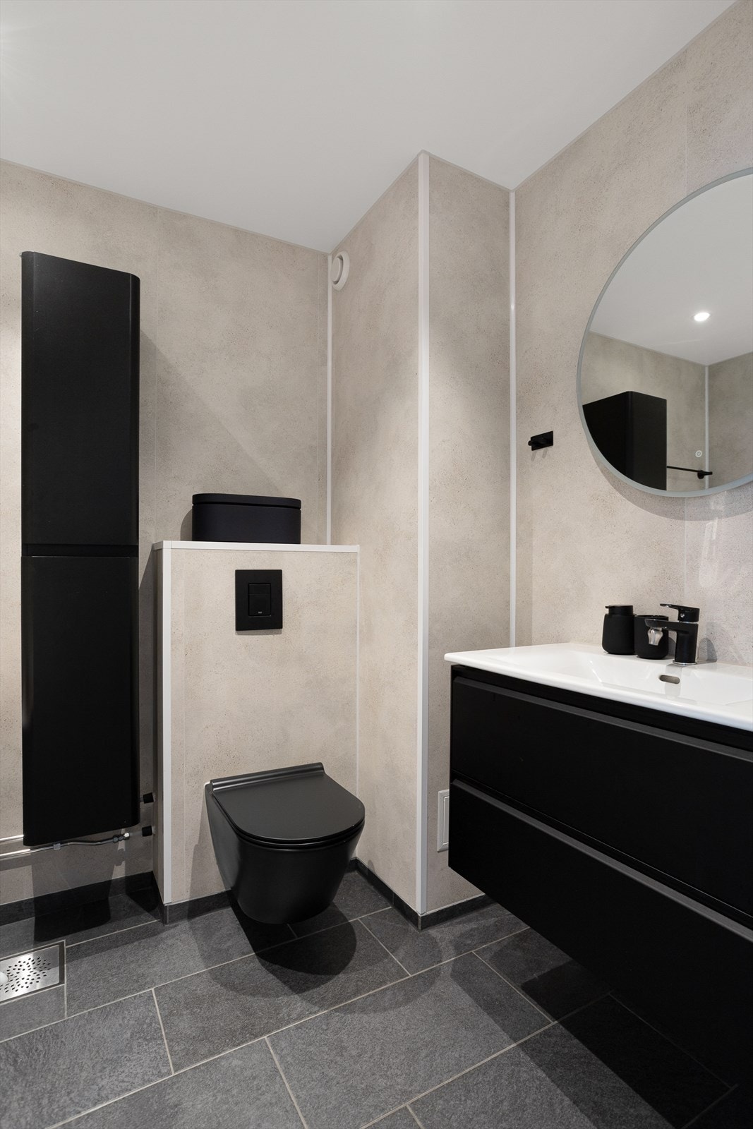 Baderommet er utrustet med veggmontert innredning med heldekkende servant, badekar, og vegghengt toalett. Galleribilde