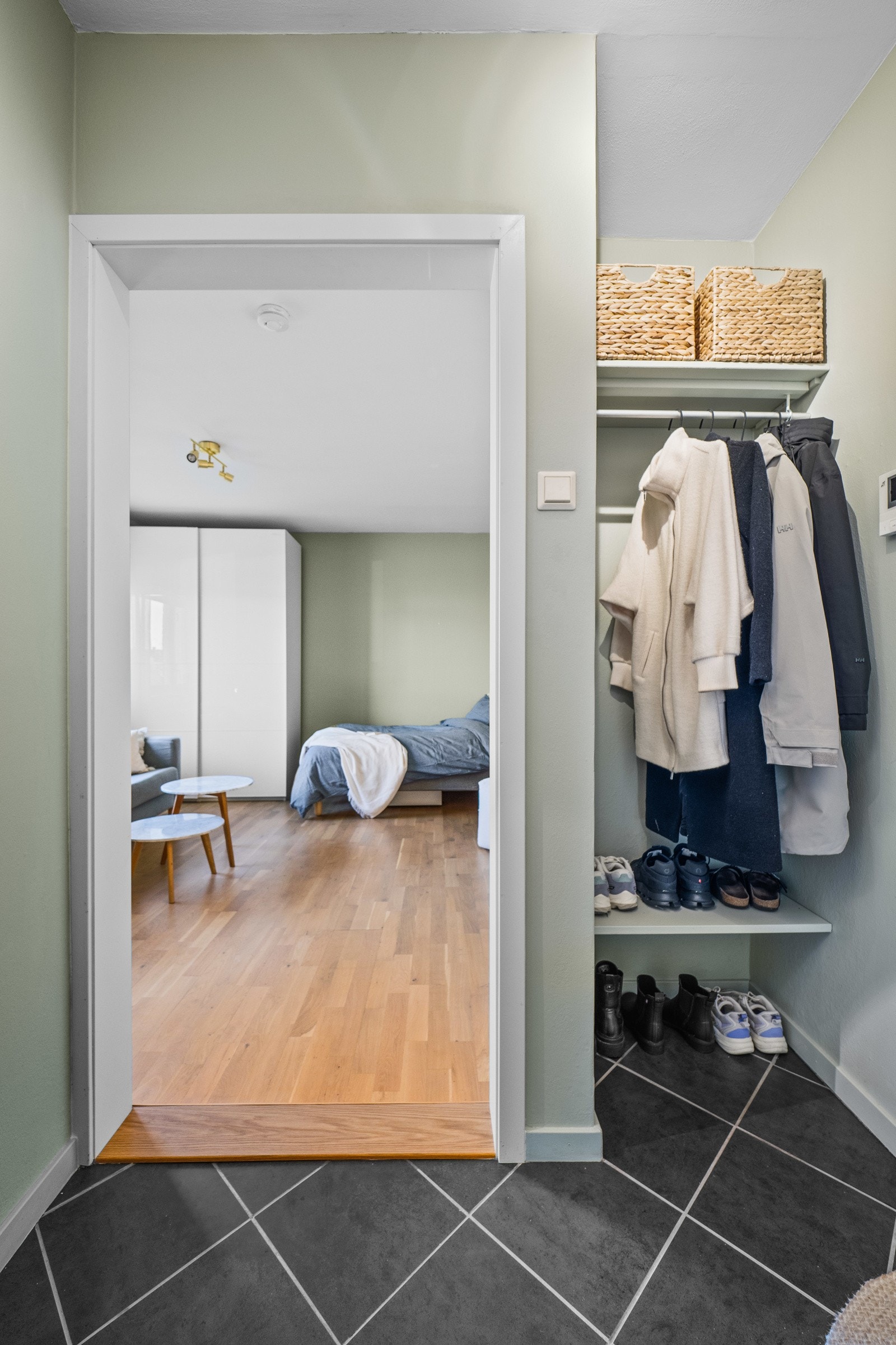 I entreen kan yttertøy og sko oppbevares i en nisje med hyller og heng. Galleribilde