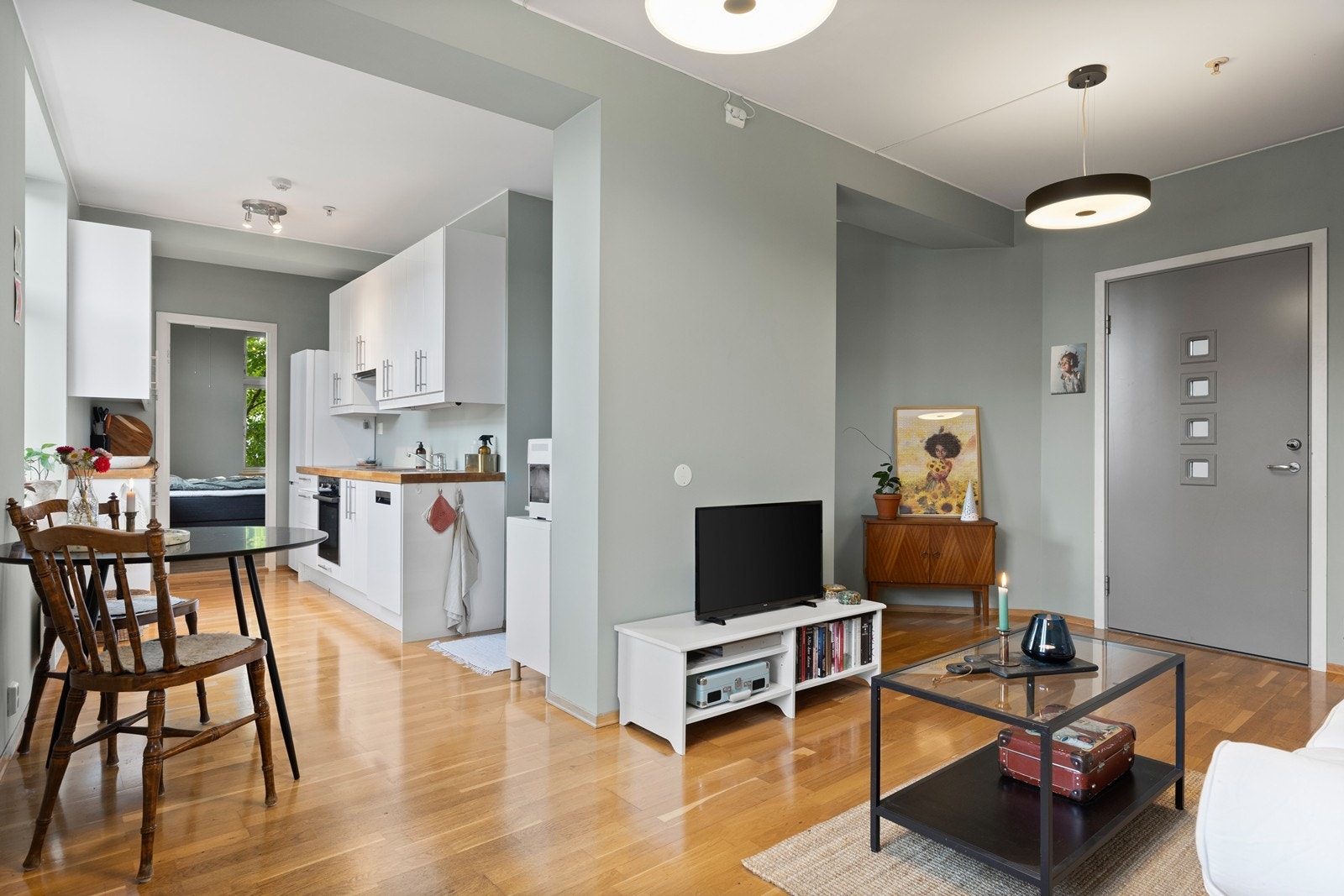 Åpen stue- og kjøkkenløsning som gir leiligheten et luftig preg Galleribilde