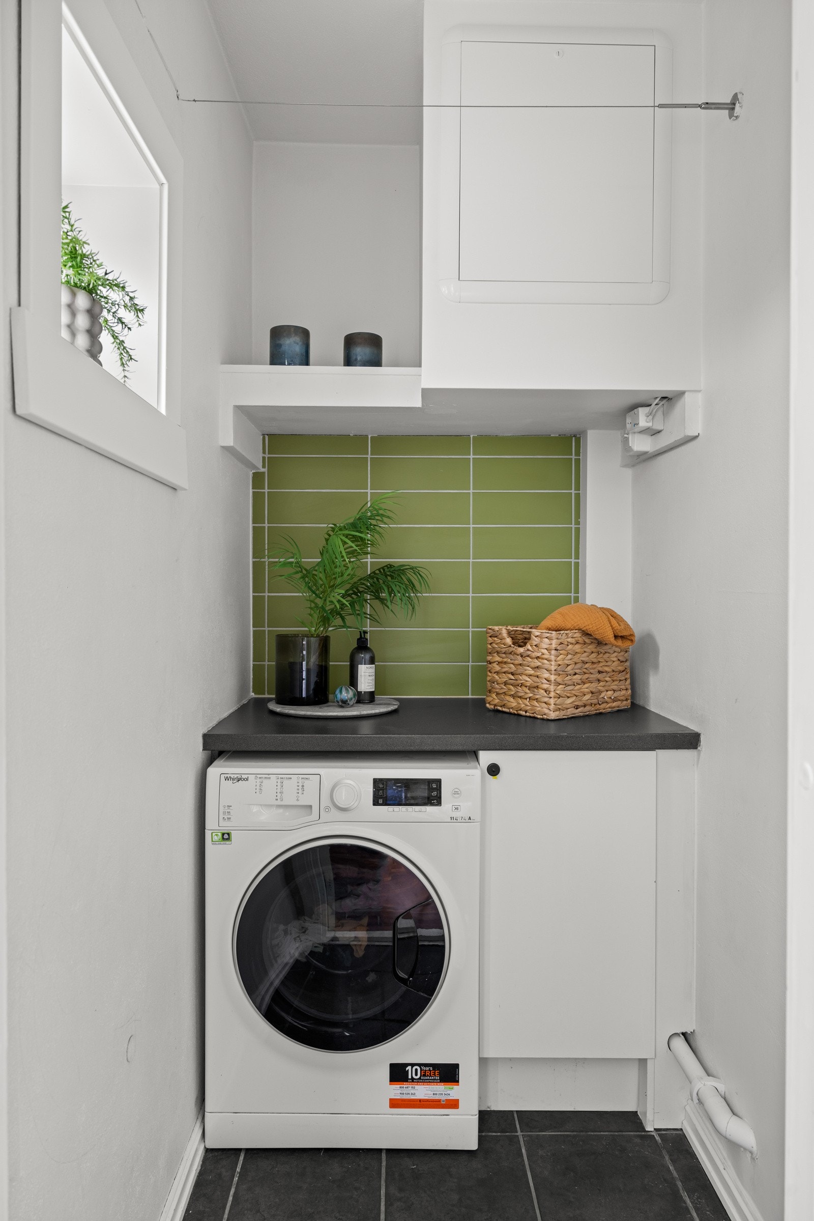 Skap og plass for vaskemaskin under laminat benkeplate i bod. Galleribilde