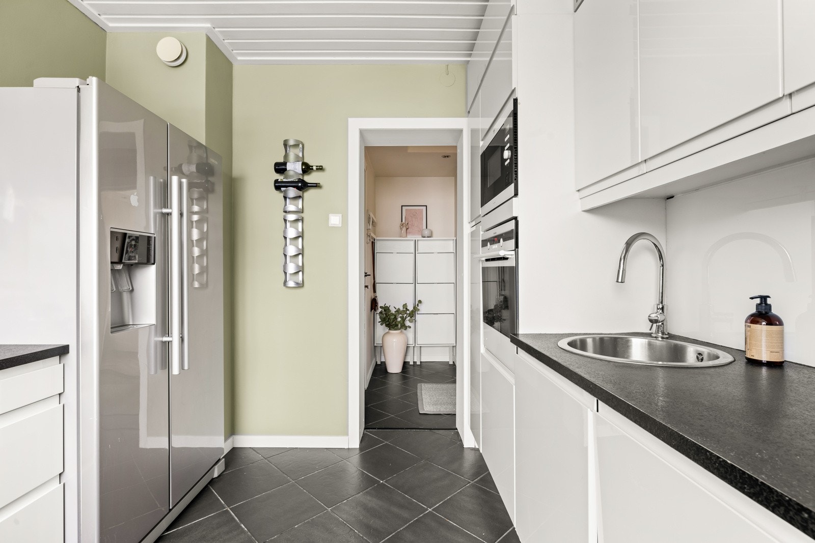 Veggplater i glass/plexiglass mellom benkeplate og overskap, samt på vegg ved keramisk topp. Galleribilde