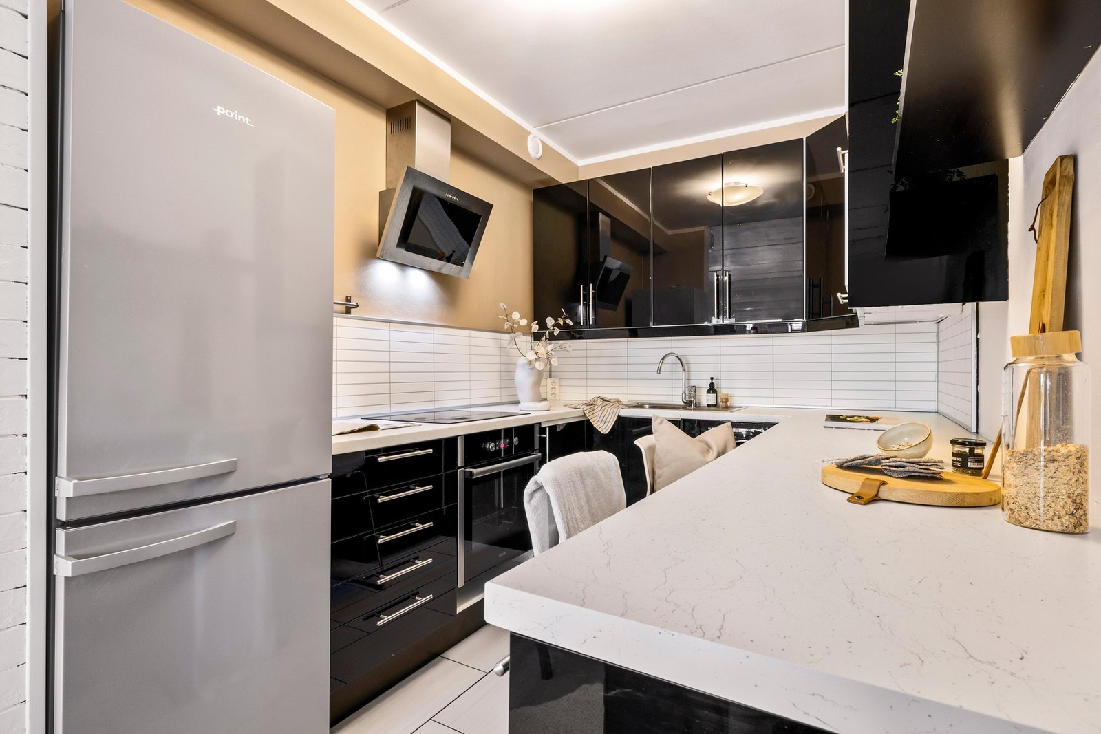 Kjøkkeninnredningen har glatte høyglansfronter og benkeplate i laminat Galleribilde