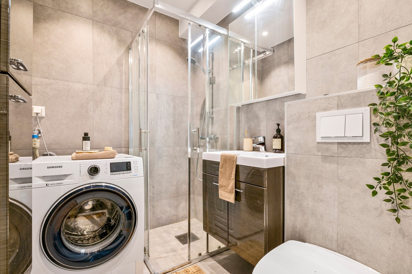 Badet er delikat innredet i moderne farger og har varmekabler i gulv Galleribilde