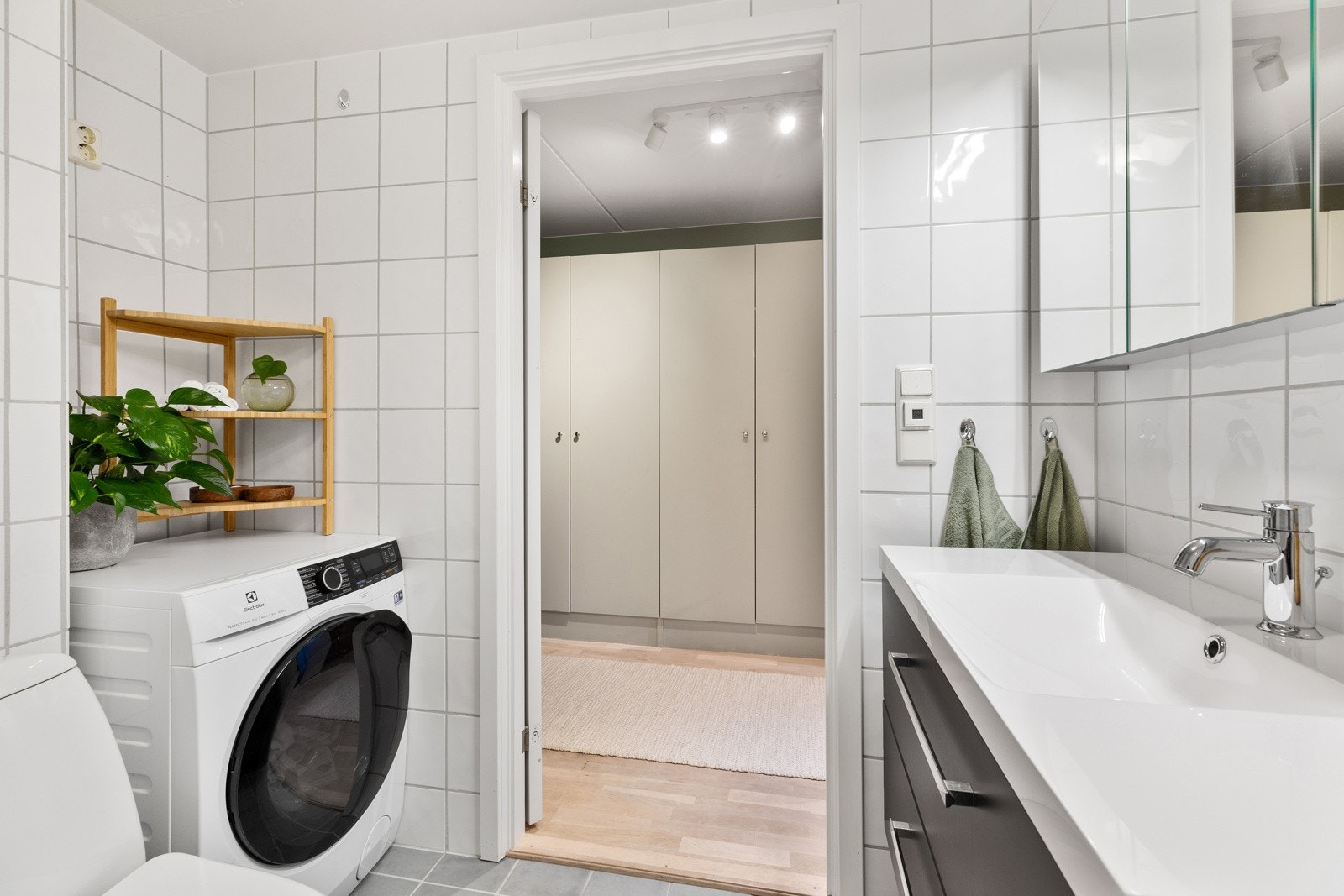 Arealeffektiv løsning med plass til dusjhjørne, servantskap med speil, toalett og opplegg for vaskemaskin Galleribilde