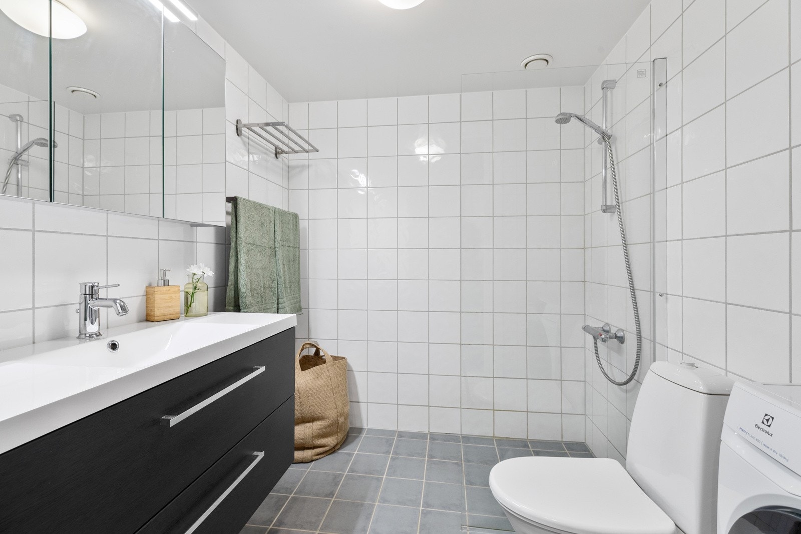 Flislagt baderom med varmekabler med lyse fliser og hvitmalt himling Galleribilde