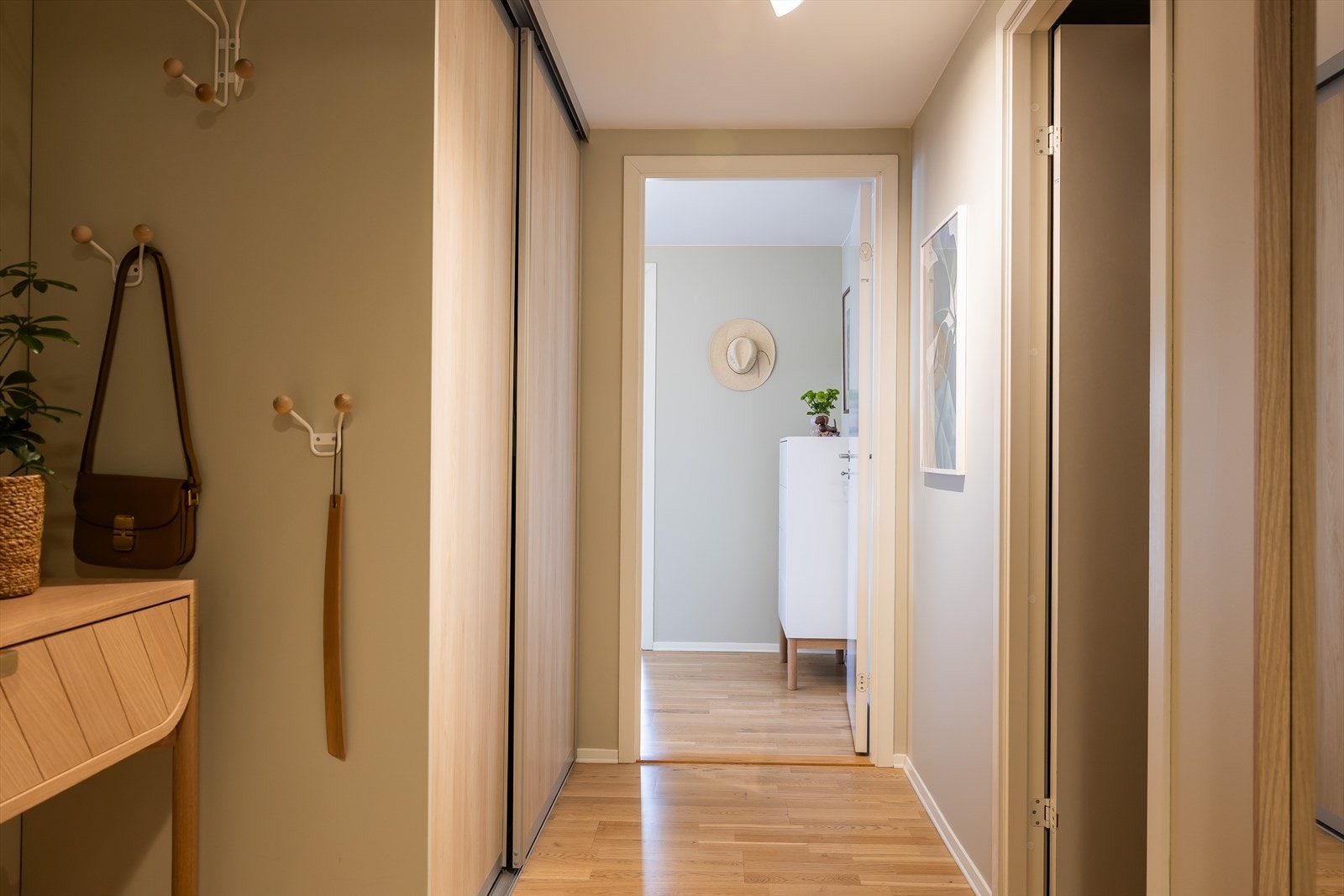 Leiligheten har en innbydende entré som skaper et umiddelbart godt førsteinntrykk. (Det gode førsteinntrykket vil høyst sannsynlig også fortsette å vare). Her er godt med plass til oppbevaring av yttertøy i romslig skyvedørsgarderobe. Galleribilde