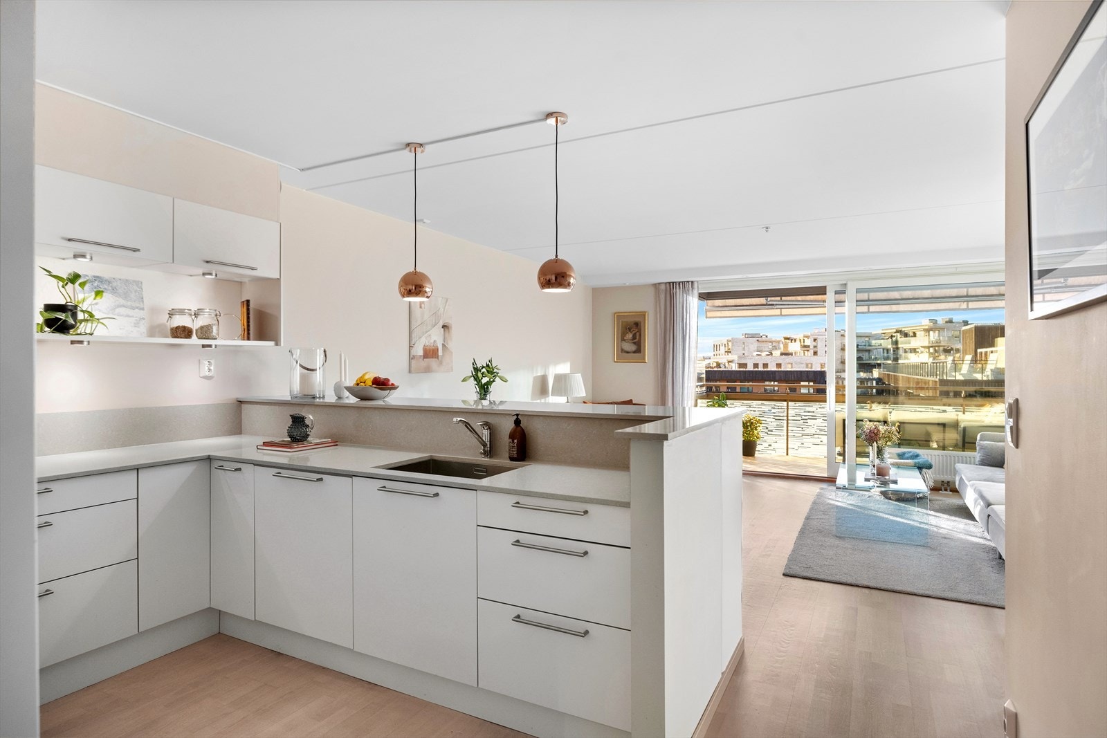 Kjøkkenet har hvite, glatte fronter, benkeplate i granitt og nedfelt oppvaskkum i rustfritt stål med ettgreps svingbart blandebatteri. Galleribilde