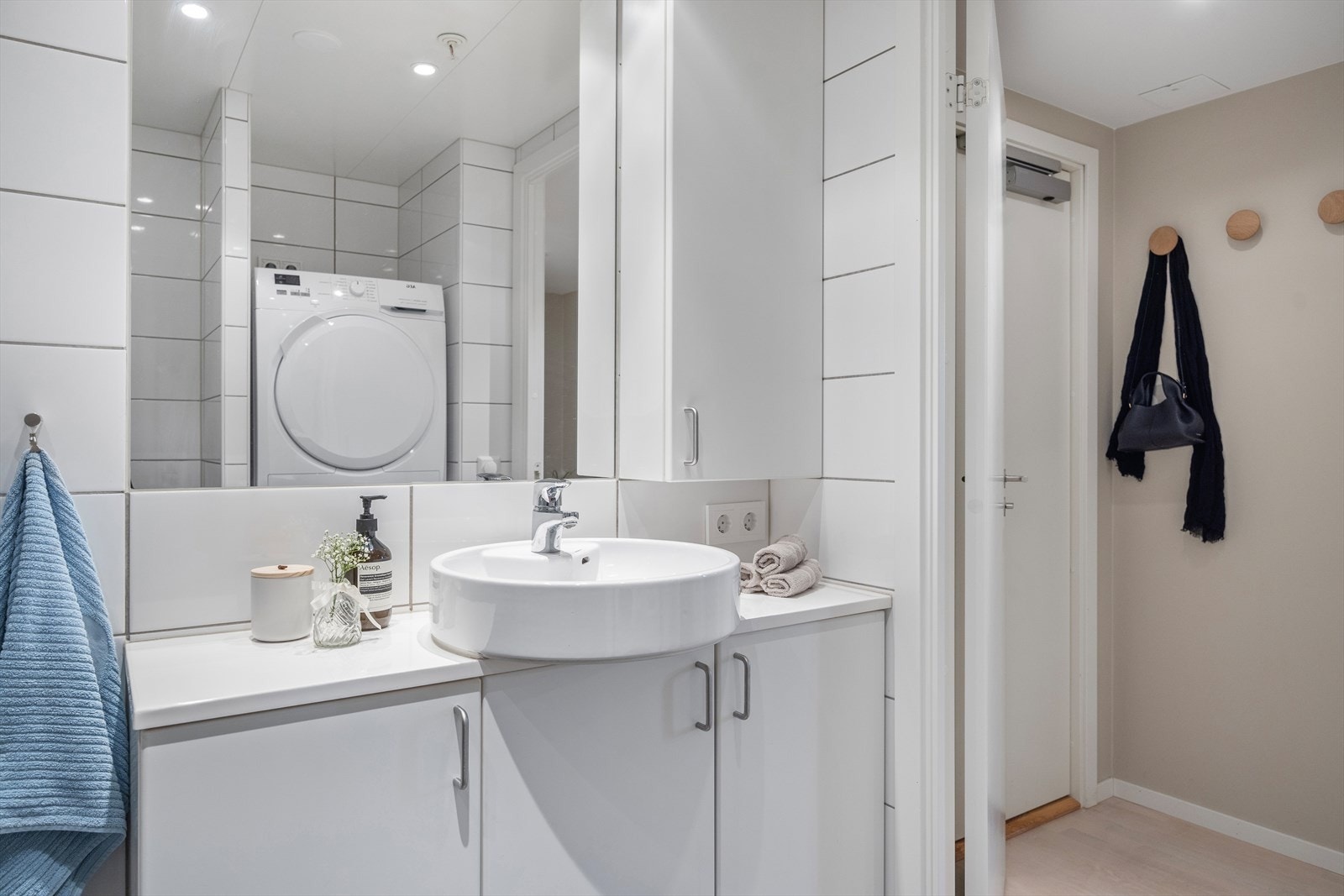 Badet er utstyrt med servantskap, speil og veggskap med belysning, vegghengt toalett med innebygd sisterne, samt innfellbare dusjvegger. I tillegg har badet en egen vaskenisje med opplegg for vaskemaskin og tørketrommel. Galleribilde